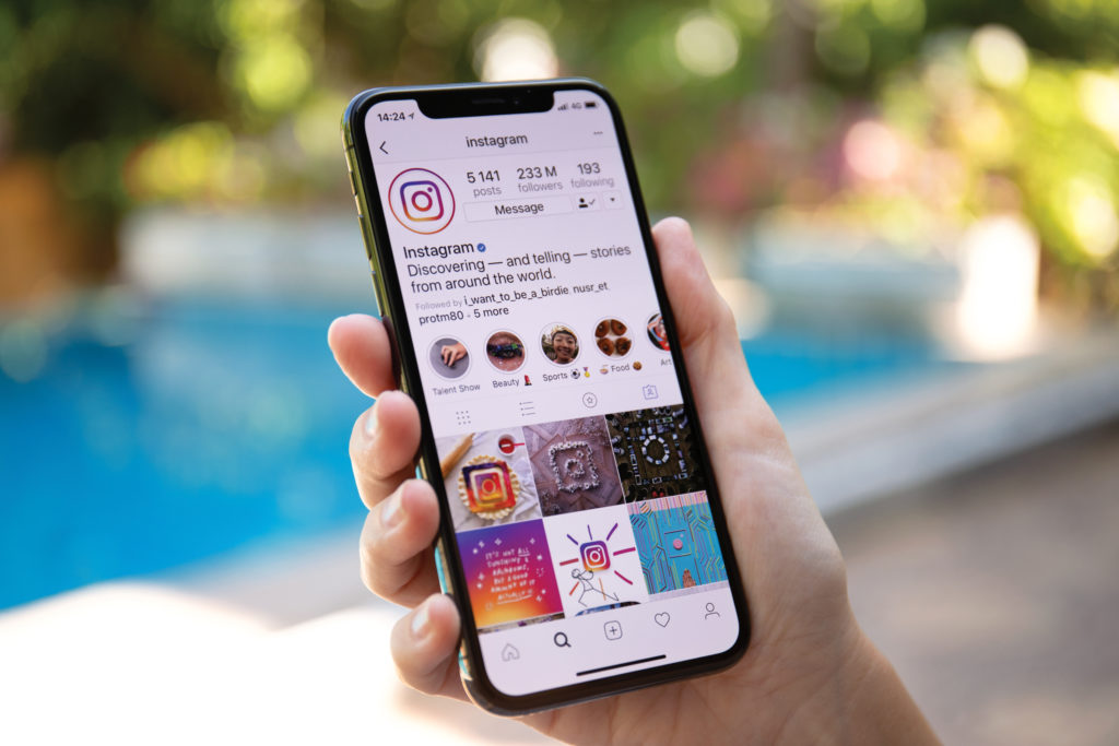 Frau hält iPhone X mit sozialem Netzwerkdienst Instagram in der Hand